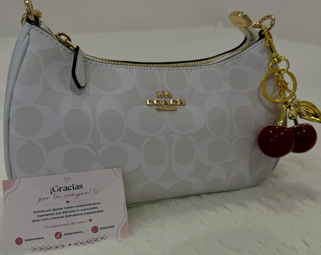 Bolso de hombro Coach Teri monograma blanco con charm de cerezas