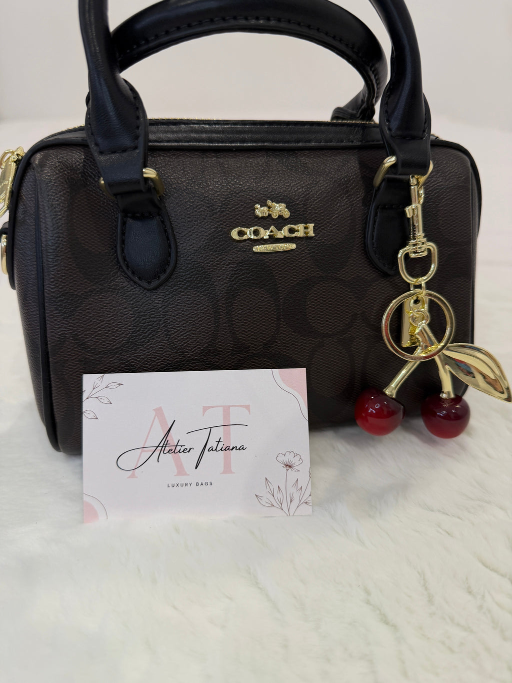 Bolso Mini Coach Rowan marrón con charm de cerezas