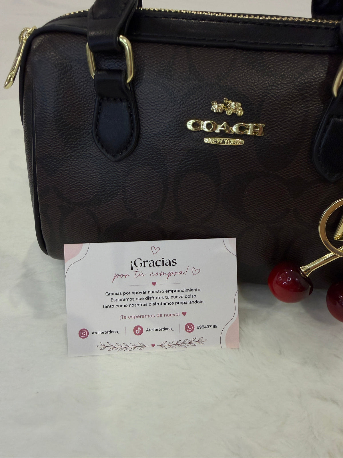 Bolso Mini Coach Rowan marrón con charm de cerezas